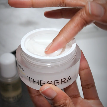 model placing finger into skincare container