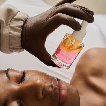 holding skincare chemical peel in front of client's face
